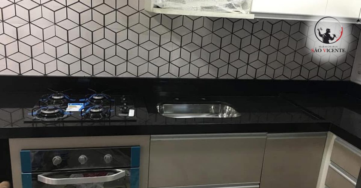 Bancada em granito preto com cooktop e cuba instalados